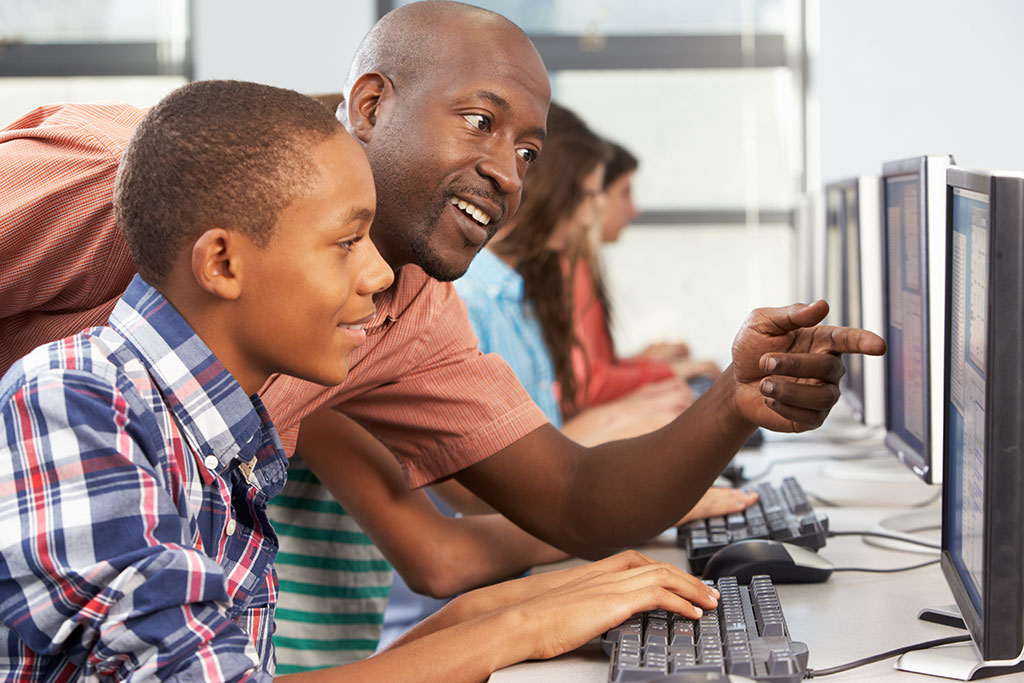 Teacher and pupil at a computer screen