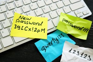 A keyboard with post-it notes scattered across it. The post-it notes have simple passwords written on them demonstrating poor small business security. 