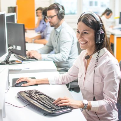 Young female technical support with hands-free device at call center Young female technical support agent with hands-free device at call center