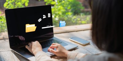 Laptop with two folders transferring files between each folder.