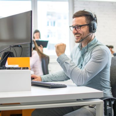 Friendly handsome male operator working on computer in office