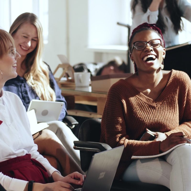 Colleagues in a meeting room laughing and talking together